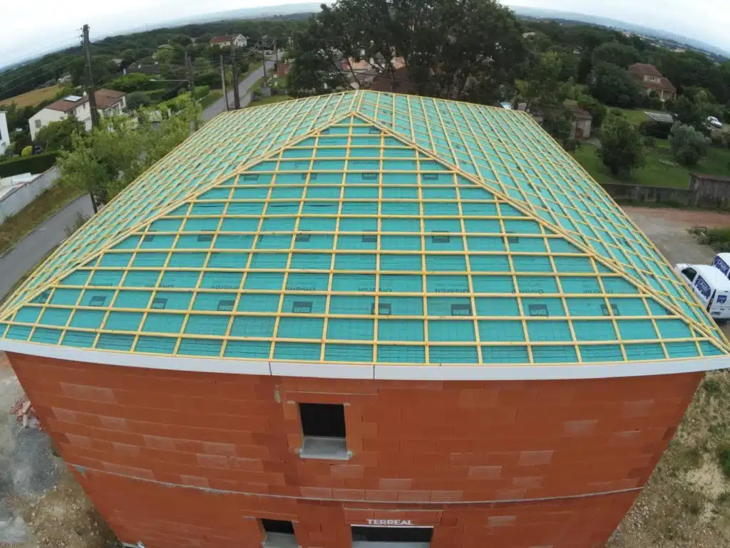  Vue aérienne d'une toiture avec pare-pluie et liteaux installés, prête pour la pose des tuiles, soulignant l'expertise dans la préparation d'une couverture de toiture.